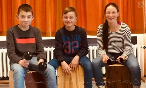 Drei Schler spielen Cajon