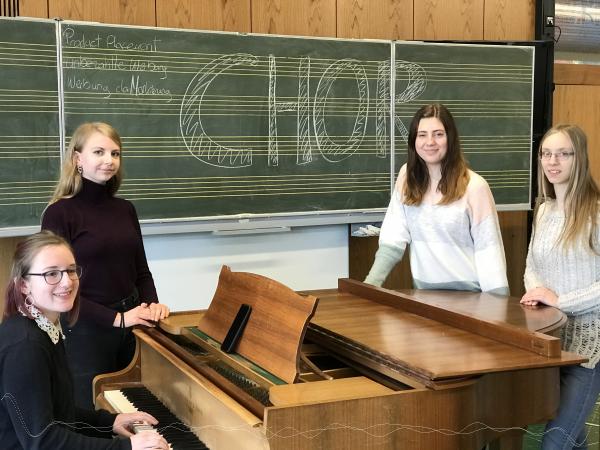 Vier Schlerinnen stehen um ein Klavier herum