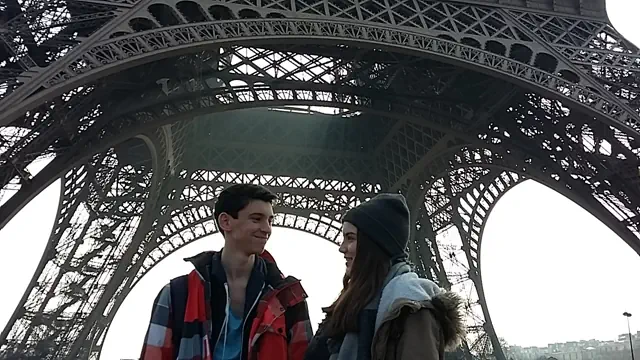 Schüler unter dem Eiffelturm sehen sich staunend an