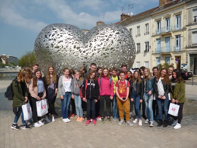 Schülergruppe in Troyes vor einem Herz aus Silber