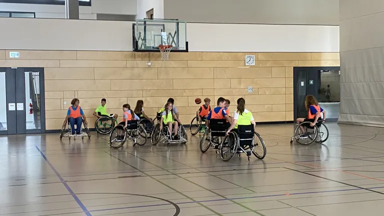 SchlerInnen spielen Rollstuhlbasketball