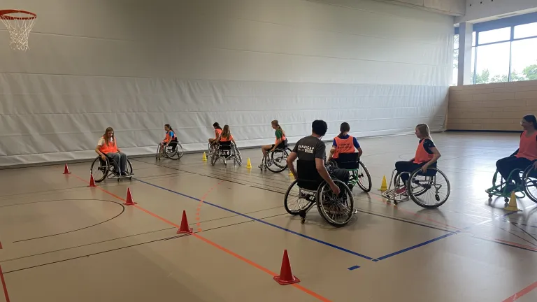 SchlerInnen fahren im Rollstuhl Slalom