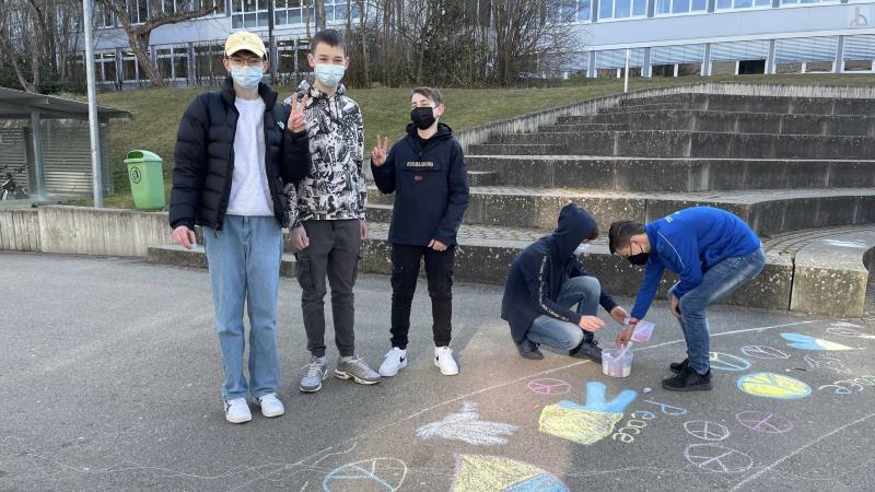 Jungs malen in Blau / Gelb Figuren auf den Boden