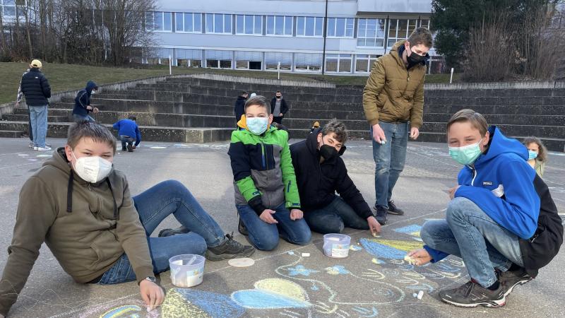 Jungs sitzen auf dem Boden und zeichnen