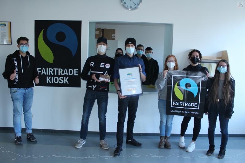 Schüler zeigen stolz die Fairtrade-Auszeichnung der Schule