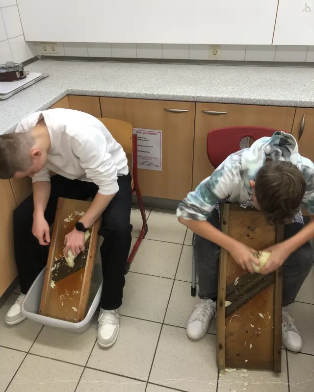 Zwei Jungs hobeln Sauerkraut