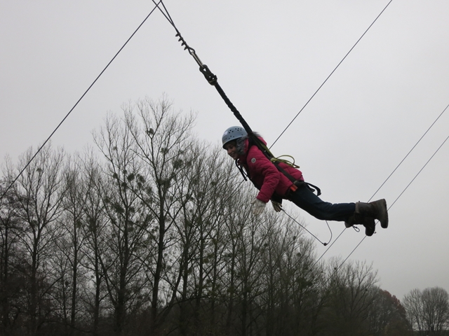 Kind hängt gesichert an einem Seil in der Luft