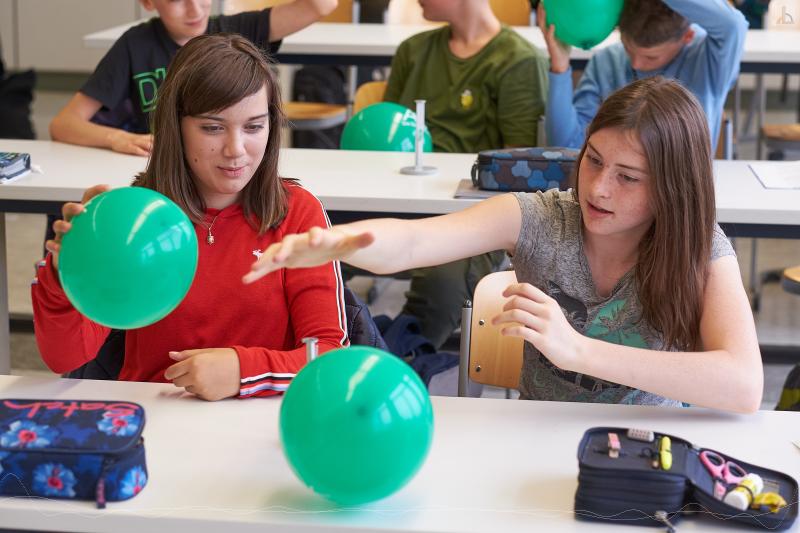 Zwei Mdchen und zwei grne Luftballons