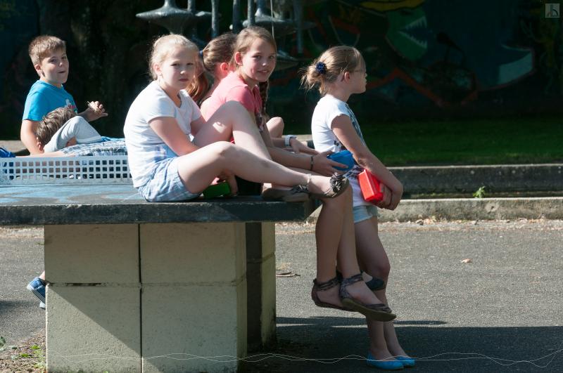 Kinder sitzen auf der Tischtennisplatte